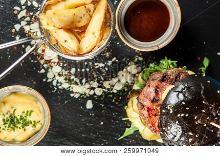 Burger And Friench Fries On Black Stone Table , Cheese Tomato And Soia Sos