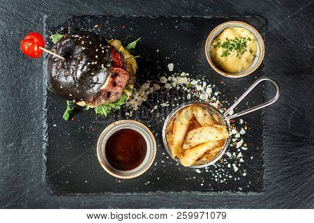 Burger And Friench Fries On Black Stone Table , Cheese Tomato And Soia Sos