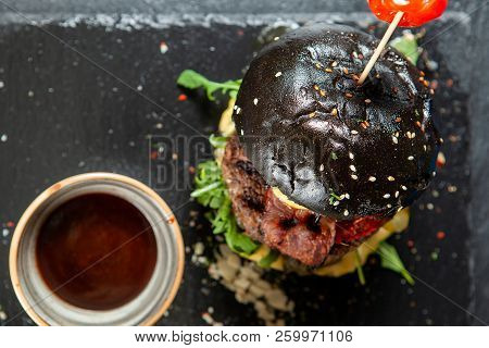 Burger And Friench Fries On Black Stone Table , Cheese Tomato And Soia Sos