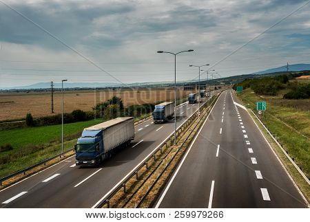 Caravan Or Convoy Of Lorry Trucks In Line On A Country Highway