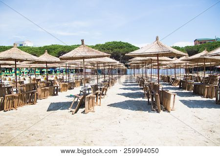 Albania. Golem. Beach Shoreline With Sun Umbrellas Made From Straw. A Blue Sky On The Adriatic Sea.