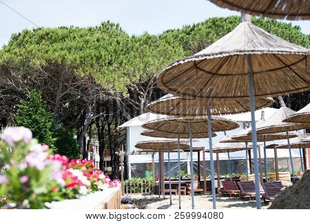 Albania. Golem. Beach Shoreline With Sun Umbrellas Made From Straw. A Blue Sky On The Adriatic Sea.