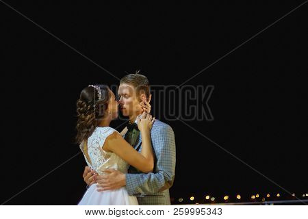 The Bride And Groom Stand On The Beautiful Porch Of The Hotel At Night