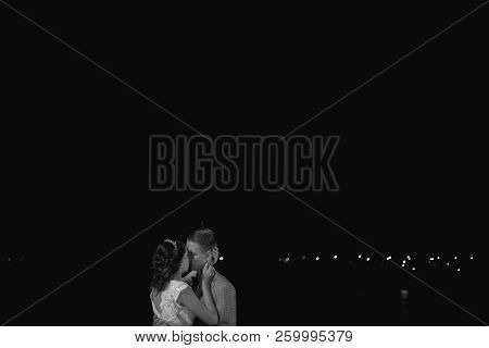 The Bride And Groom Stand On The Beautiful Porch Of The Hotel At Night