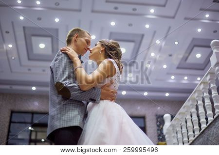 The Bride And Groom Stand On The Beautiful Porch Of The Hotel At Night