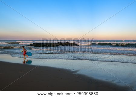 Avon By The Sea, New Jersey-september 16: A Young Boy With Toy Runs On The Beach At Dusk On Septembe