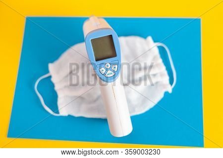 Thermometer And Medical Mask On A Blue Background