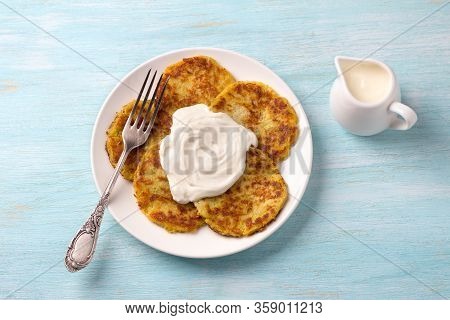 Traditional Latkes Fritters With Sour Cream On Light Blue Textured Background, Top View