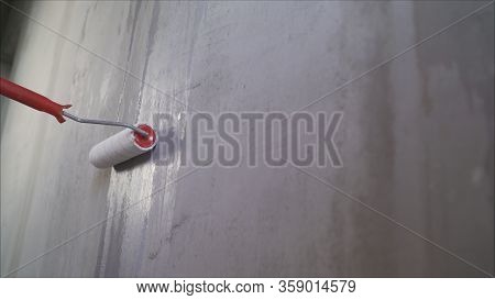 The Process Of Applying A Primer To A Wall Using A Roller. The Primer Solution Is Applied To The Wal