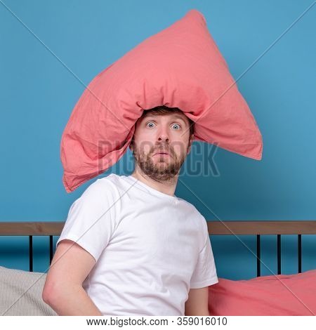 Cauacsian Young Man With Pillow On Head Lying In Bed And Screaming Being Alone Stressed Because Of Q
