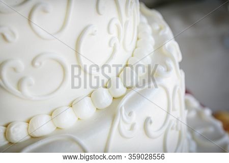 White Fondant Icing With Decorative Swirls On A Wedding Cake