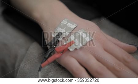 Two Electronic Sensors On A Female Hand, Red And Black