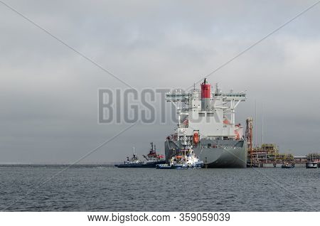 Lng Terminal And Gas Tanker - A Large Ship Maneuvers Into The Unloading Quay