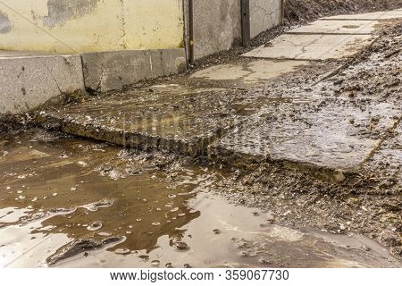 A Muddy Stream Runs Over Concrete Tiles