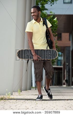 En ung mand med Skateboard og taske