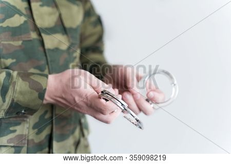 Police Officer With Handcuffs In Khaki Colored Uniform Stops And Arrest Criminal On The Street For V