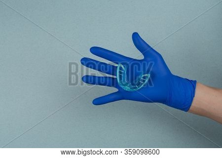 Myofunctional Trainer For Correction Of Bite And Alignment Of Teeth In The Hand Of Doctor In The Glo