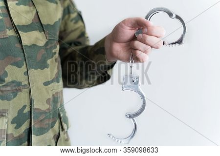 Police Officer With Handcuffs In Khaki Colored Uniform Stops And Arrest Criminal On The Street For V
