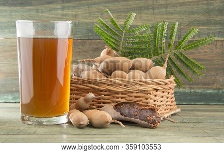 Tamarind Juice In A Glass Surrounded By Fresh Ripe Tamarinds - Tamarindus Indica