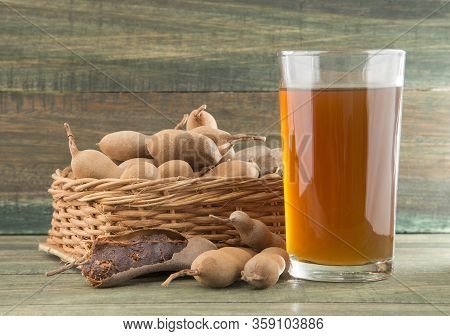 Tamarind Juice In A Glass Surrounded By Fresh Ripe Tamarinds - Tamarindus Indica