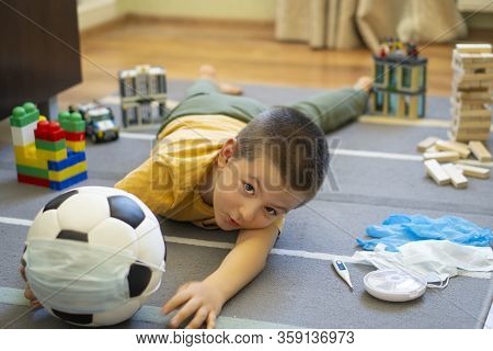 Soccer Ball In A Medical Mask. Activities At Home With Your Children During Home Coronavirus Quarant