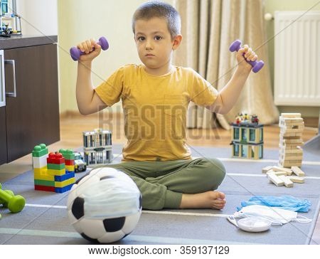 Soccer Ball In A Medical Mask. Activities At Home With Your Children During Home Coronavirus Quarant