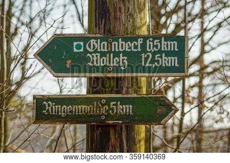 Poratz, Brandenburg, Germany - March 11, 2018: Old Weathered Wooden Signpost Directing To The Hamlet