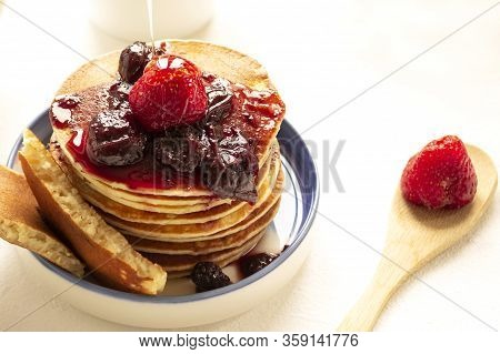 Closeup Of Delicious Pancakes, With Fresh Strawberries And Maple Syrup On A Light Background. With S