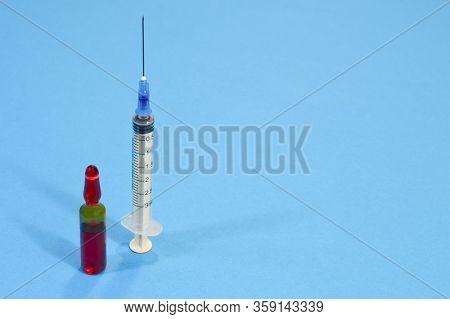 Ampoule And Syringe On The Blue Background, Concept Of Medicine And Panacea For All Viruses, Copy Sp