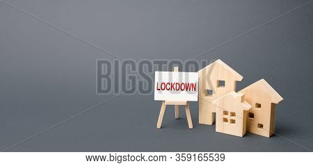 Figures Of Houses And An Easel With The Word Lockdown. Tough Measures To Stop New Infections Of Coro