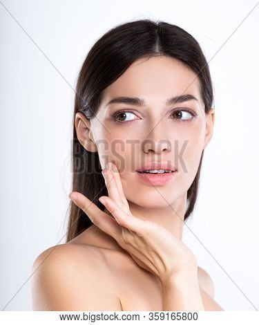 Portrait of beautiful young brunette woman with clean face. Beautiful face of young adult woman with clean fresh skin - isolated on white. Front portrait of woman with beauty face. Beauty concept 