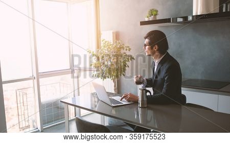 Businessman Works From Remote At House With A Laptop Due To Coronavirus Quarantine.