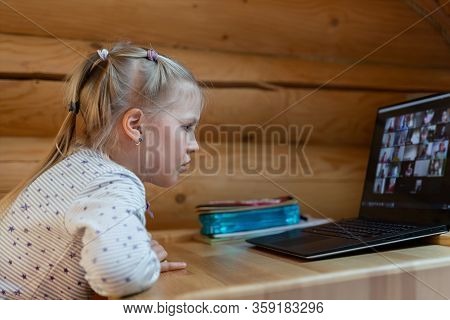 Cute Adorable Caucasian Little Blond Girl Siiting At Desk With Laptopn During Online Video Chat Scho