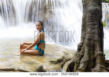 Woman In Swimsuit Sit At Huai Mae Khamin Waterfall And Natural In Kanchanaburi Province Thailand.
Hu