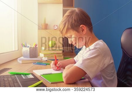 Happy Child Boy Wirting In His Copybook, Doing Homework At Home