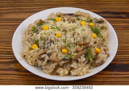 Tasty Appetizing Risotto On A White Plate On A Wooden Table