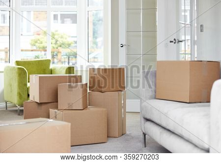 Cardboard Carton Boxes Stack With Household Belongings In Modern House Living Room. Packed Container