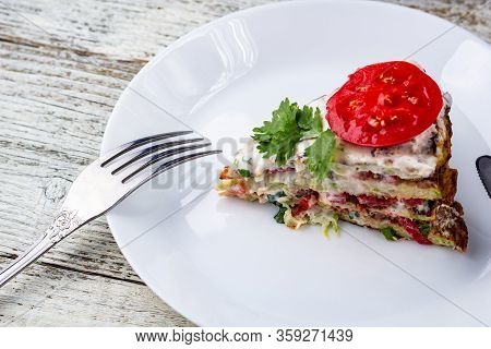 Pice Of Zucchini Cake With Tomatoes And Fresh Parsley On White Wooden Background.