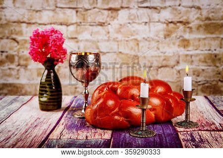 Shabbat Candles In Candlesticks Of Loaves Challah For Shabbat Wine In A Kiddush Cup With Flowers