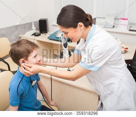 Female Otolaryngologist Doing A Hearing Test In A Boy. Tympanometry Measures The Pressure In The Mid