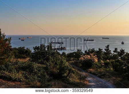 road from a wild beach, forest and view of the black sea, cargo ships on the outskirts of the resort of Gelendzhik. Black sea coast