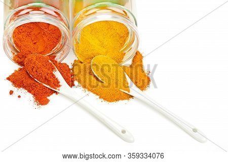 Turmeric And Chili Pepper Powder In Glass Jar. Heap. Spoon. Isolated On White. Free Space For Text.