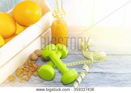 Lots Of Oranges, Dumbbells, Measuring Tape On A Wooden Textured Background. Fitness, Sports Nutritio