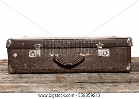 Old Brown Suitcase For Travel Lyies On The Wooden Table