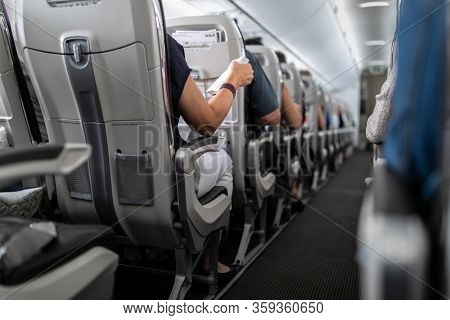 Interior of commercial airplane with passengers in their seats during flight.
