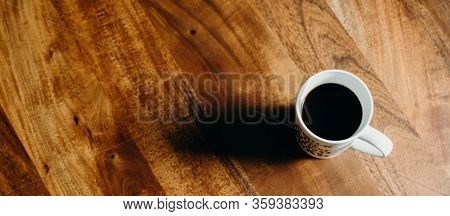 A White Cup Of Cofee On Wooden Table.