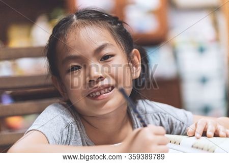 Portrait Cute Asian Child Girl At Home, Doing Homework Or Lesson, Focus, Concentrate To Lesson, Hair