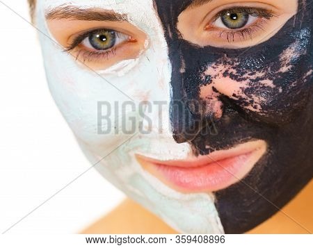 Woman With Clay Carbo Black Mask On One Half Face And White Mud On Second Half. Girl Removing Cosmet