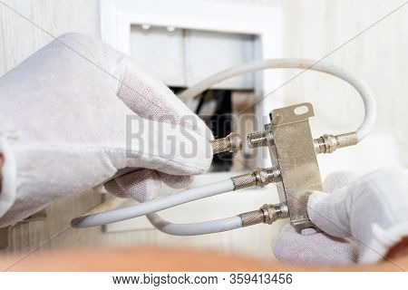 Worker Inserts Connector Of A Tv Antenna Coaxial Cable To A Splitter.