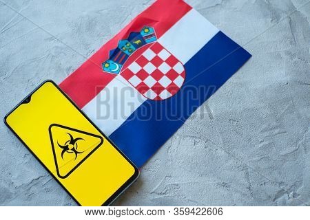 Epidemiological Situation In The Country Croatia. Flag And Smartphone With News And A Biohazard Symb